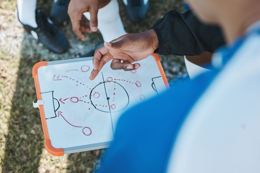 Coach explaining tactics on a clipboard